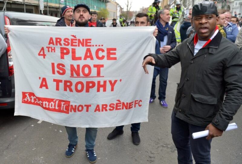 An Arsenal fan holds a sign