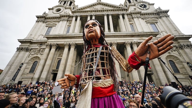 The 3.5-metre tall puppet climbed the cathedral steps before handing a gift to the dean.