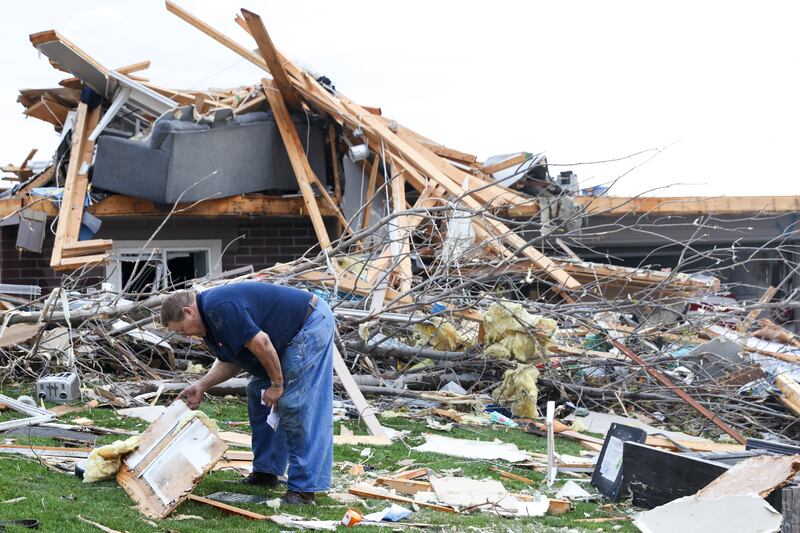 Terry Kicking sifts through the damage after a tornado levelled his home in Omaha (Nikos Frazier/Omaha World-Herald via AP)