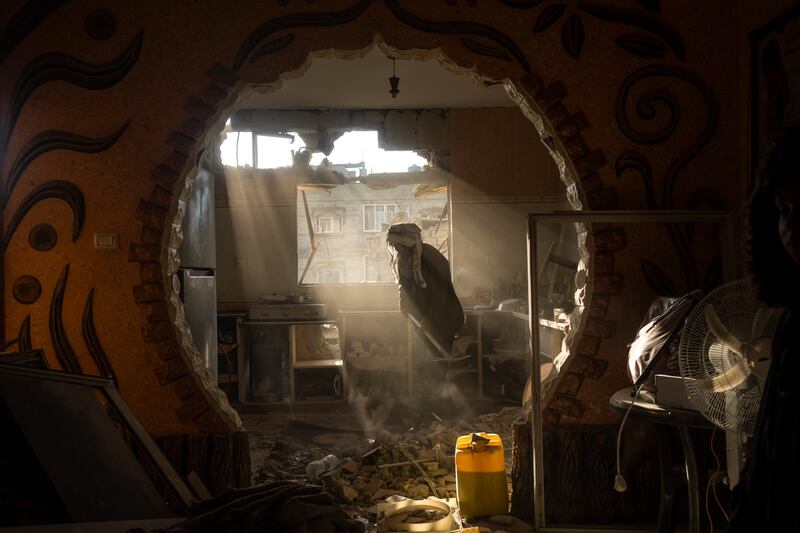 Palestinians look at their neighbour’s damaged house following an Israeli air strike in Rafah (AP Photo/Fatima Shbair)