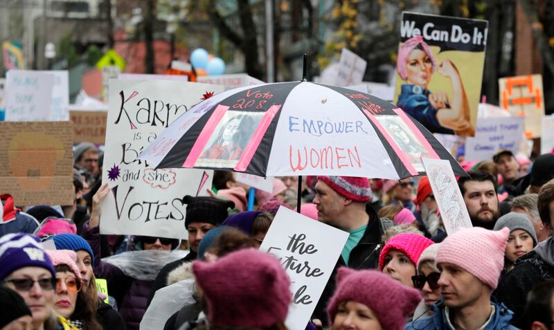 An umbrella reads "Empower Women" in Seattle on Saturday (Ted S. Warren/AP)
