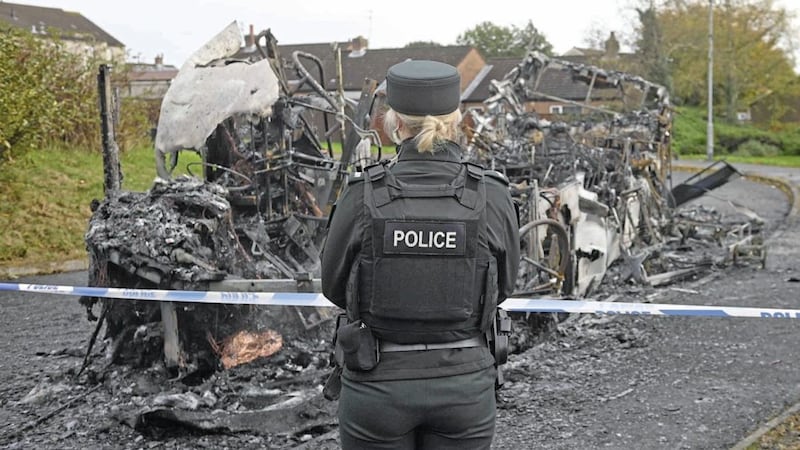 A PSNI officers surveys the burned out remains of a bus in Newtownards earlier this month. Picture by Mark Marlow. 