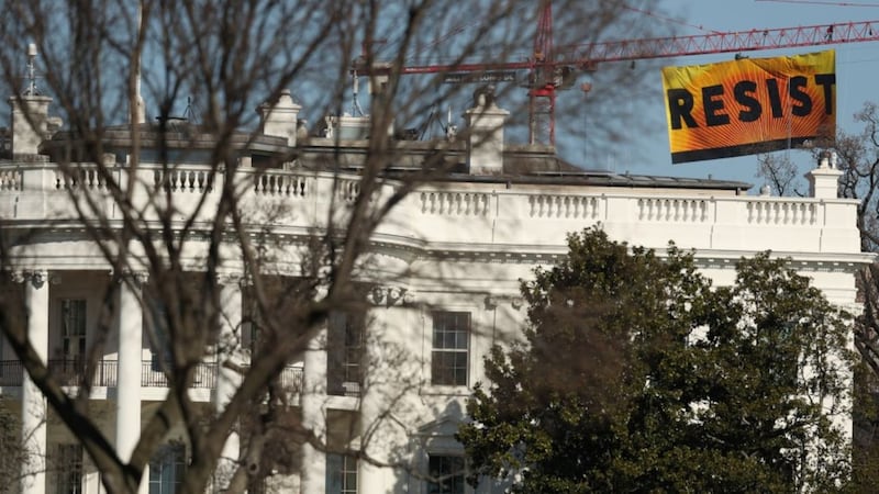 Greenpeace activists scaled a crane behind the White House to protest against Trump