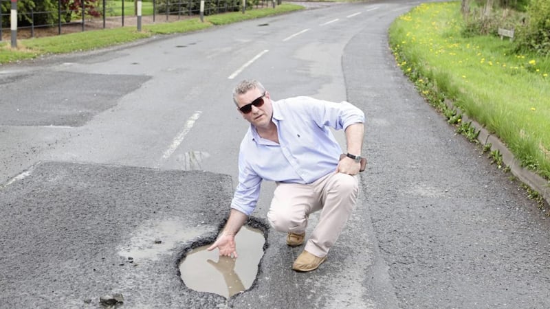 Martin Kelly reaches into one of the potholes on the Ballygassoon Road. 