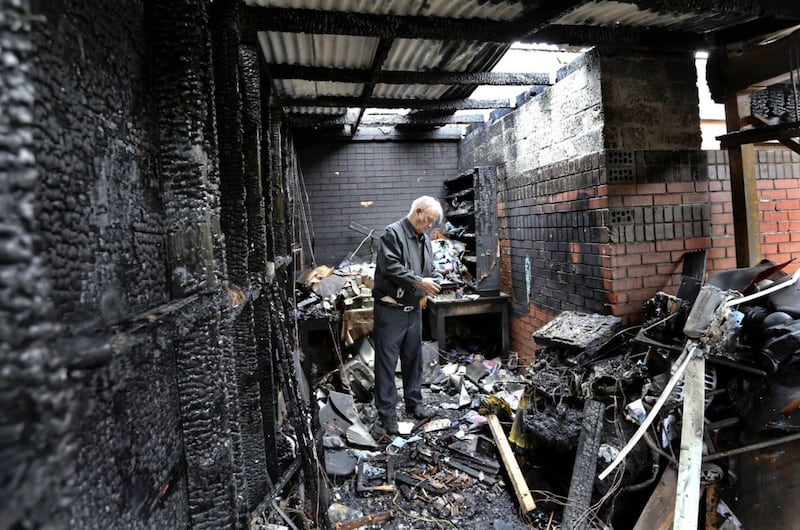 Fr Paddy O&#39;Kane stands among the burnt remains following a deliberate fire that was started in the garages at the back of Holy Family Church in Derry city on Friday night. The parochial house and the church itself were also damaged in the blaze. Youths were captured on CCTV where the blaze was started. Picture Margaret McLaughlin 25-5-2019 &copy; 