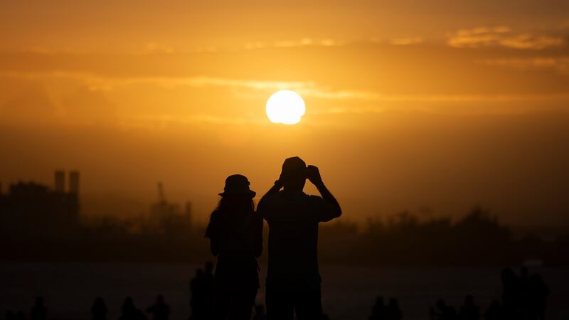 People watch the sunset during the San Sebastián Street festivities in San Juan, Puerto Rico on January 21 (AP)