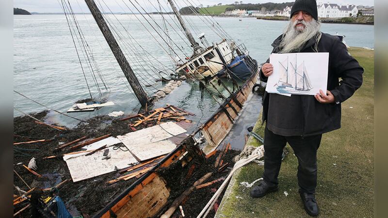 &nbsp;William Mulhall, owner of the historic Tall Ship Regina Caelis, which sank at the quayside in Portaferry, Co Down last month, holds a photograph of the ship at Strangford Lough where the vessel remains