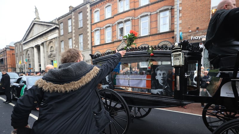 Flowers are thrown at the hearse as the funeral procession of Shane MacGowan makes its way through the streets of Dublin ahead of his funeral in Co Tipperary. Picture by Liam McBurney/PA Wire