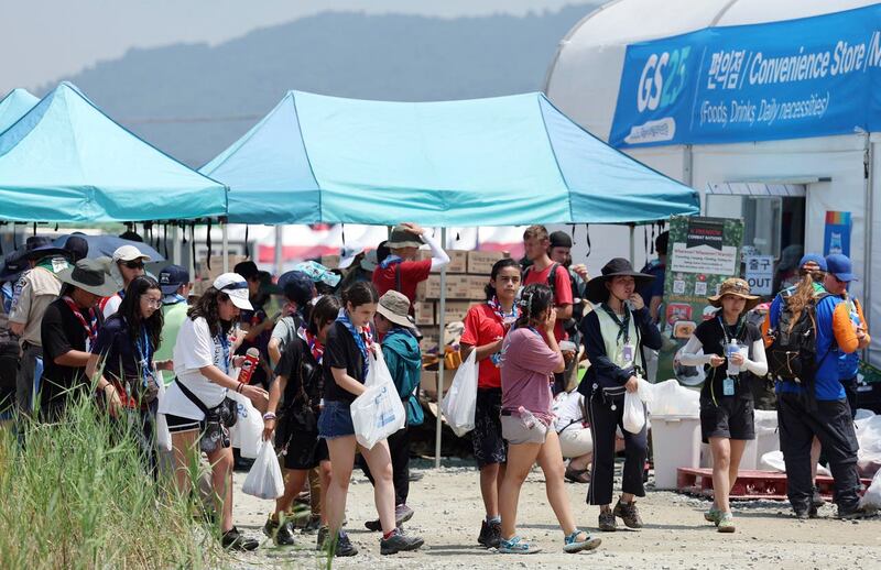Attendees of the World Scout Jamboree leave a convenience store at the scout camping site in Buan, South Korea 