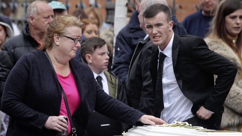 Carol Corr places a hand on her daughter Joleen&#39;s coffin during the 27-year-old&#39;s funeral in west Belfast. Photo by Matt Bohill 