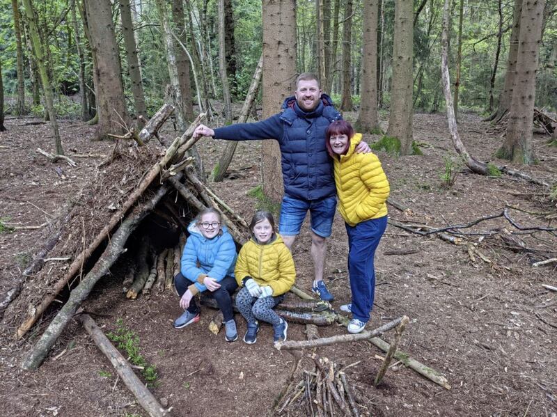 Claire Spreadbury and her family outside the den they built in the forest 
