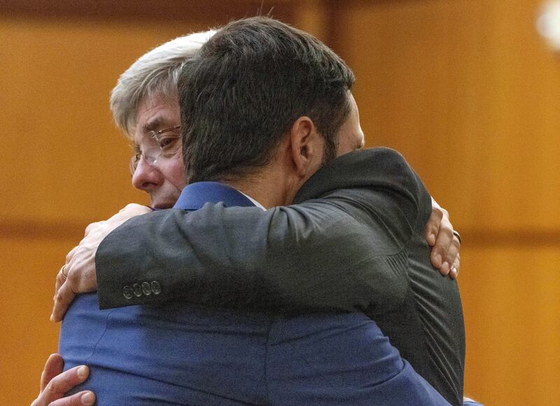 Tacoma police officer Christopher Burbank, right, gets a hug from his lawyer Wayne Fricke after he was declared not guilty (Ellen M. Banner/The Seattle Times via AP, Pool)