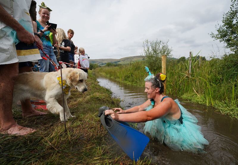 Louise Wild is greeted by her dog after taking part in the Rude Health World Bog Snorkelling Championships at Waen Rhydd peat bog in Llanwrtyd Wells, Wales 