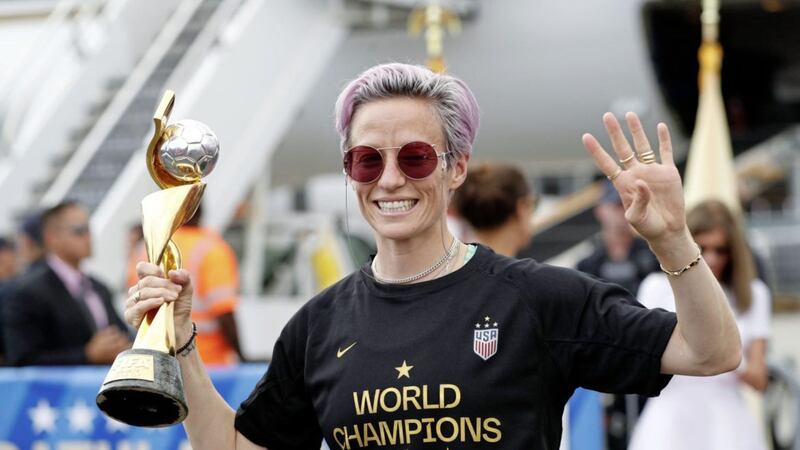 US women&#39;s soccer team member Megan Rapinoe holds the Women&#39;s World Cup trophy. She voiced her allegiance to LGBTQ+ groups during Pride month 