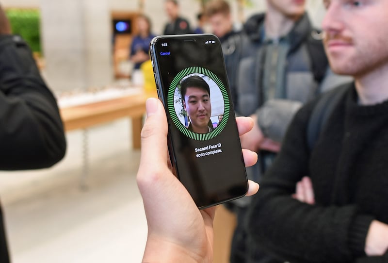 A man uses the facial recognition feature on an iPhone X 