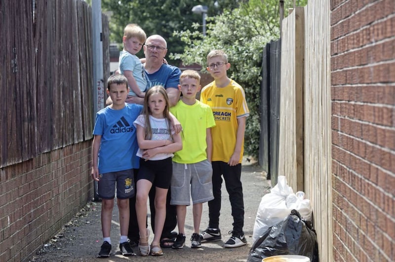 John Lyttle pictured at the back of his house at McCleery Street in north Belfast with his grandchildren. Photo by Mark Marlow 