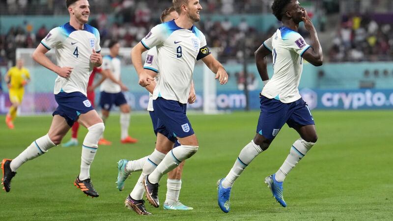 England's Bukayo Saka (right) celebrates scoring their side's fourth goal of the game during the FIFA World Cup Group B match at the Khalifa International Stadium in Doha, Qatar.