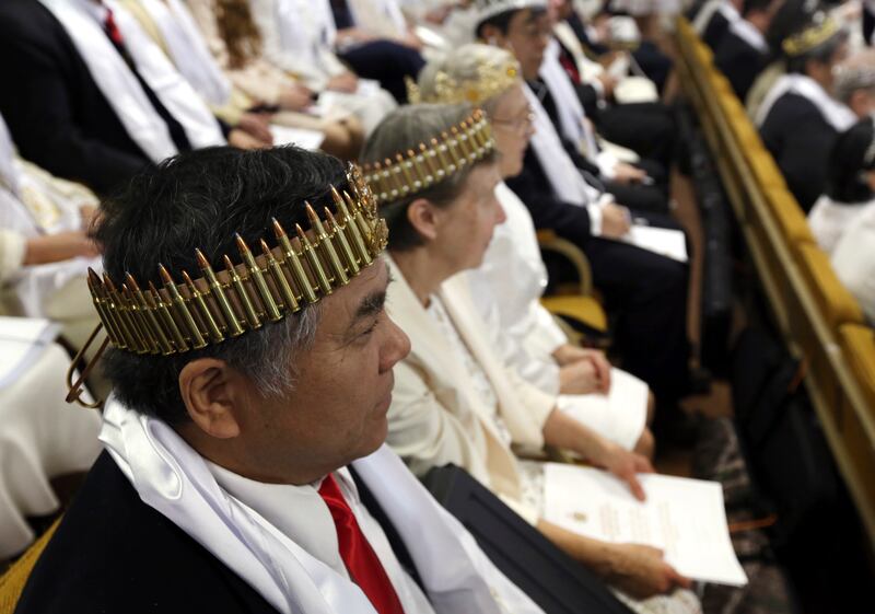 A man wears a crown of bullets at the ceremony (Jacqueline Larma/AP)