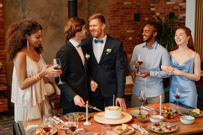 gay couple smiling happily while celebrating at wedding reception