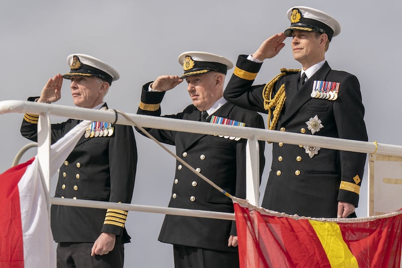Prince Edward, the Duke of Edinburgh, alongside Commanding Officer Captain Duncan Vernoum (left) and Commodore David Eagles (centre) salute the ship’s ensign during the Service of Dedication