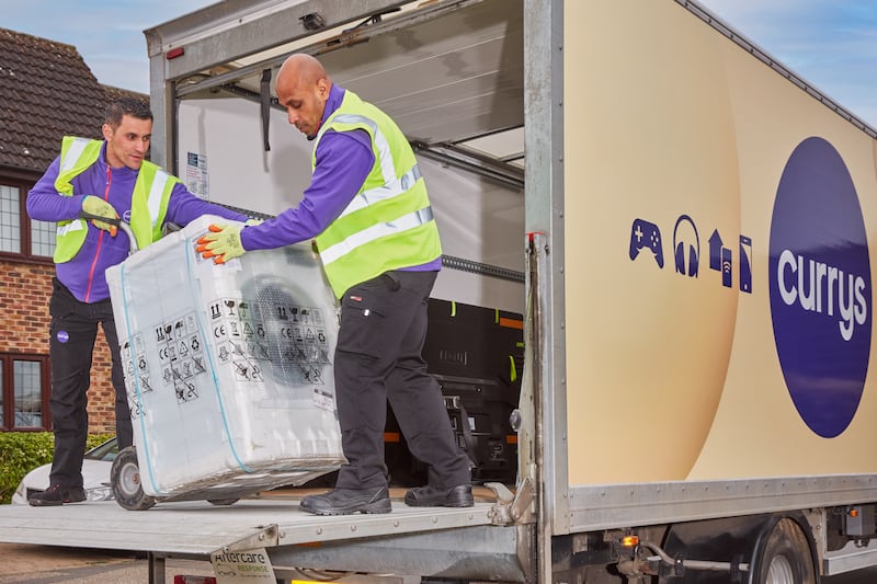 Currys workers deliver a washing machine