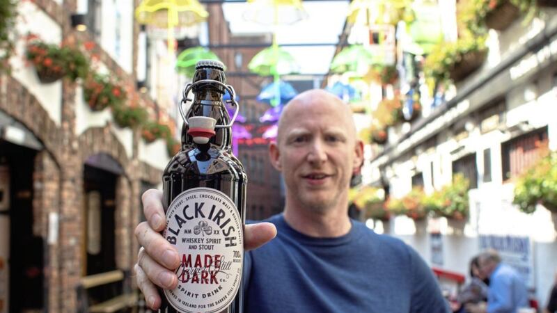 Richard Ryan displays his company&#39;s Black Irish Whiskey outside the Duke of York pub in Belfast. 