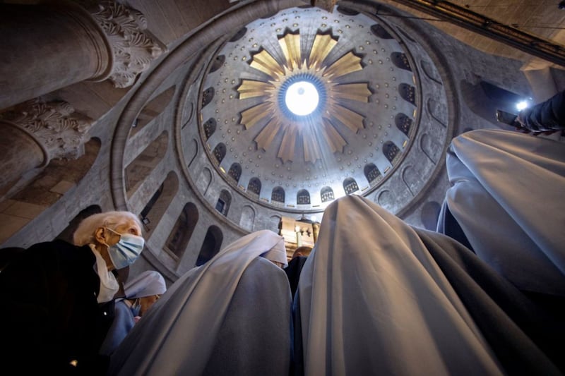 A woman wearing a face mask attends Easter Sunday Mass led by Latin Patriarch of Jerusalem Pierbattista Pizzaballa at the Church of the Holy Sepulchre in the Old City of Jerusalem. Tradition holds that the church is built on site where Jesus was crucified, buried and rose from the dead. Picture by AP Photo/Oded Balilty 
