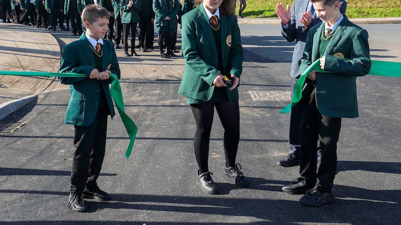 Coláiste Feirste year 8 pupils Niamh Groves with the help of Brannan Mulvena and Claodan MacDomhnaill cut the ribbon welcoming the 186 first years to the new dedicated building. Picture by Mal McCann