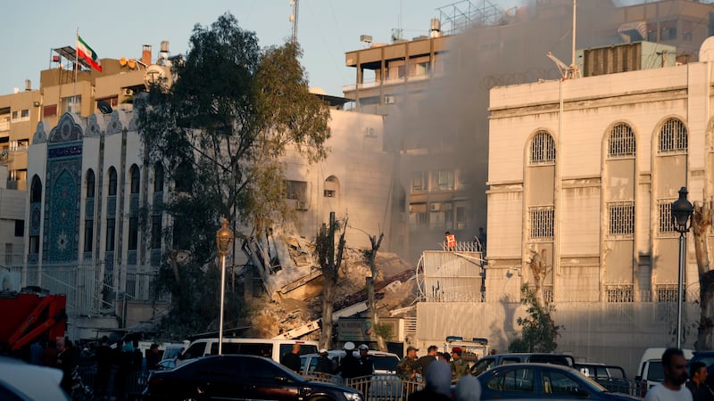 Emergency services at the building in Damascus (Omar Sanadiki/AP)