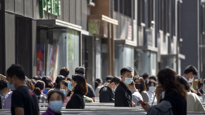 People wearing face masks stand in line for coronavirus tests in a neighborhood in the Dongcheng district of Beijing, Tuesday, April 26, 2022 (AP Photo/Mark Schiefelbein)&nbsp;