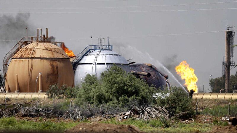 Iraqi firefighters trying to extinguish a fire at a natural gas plant in Taji, 12 miles (20 kilometers) north of Baghdad on Sunday. The coordinated assault launched on Sunday by the Islamic State group killed 14 people, according to Iraqi officials. The plant reopened to workers yesterday, as a series of IS bomb attacks targeting Shiites killed at least 69 people in the capital 