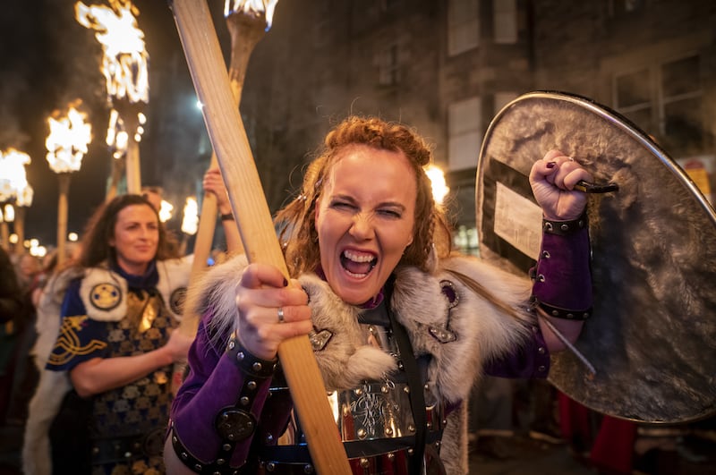 A member of the Shetland South Mainland Up Helly Aa Jarl Squad takes part in the torchlight procession through Edinburgh city centre