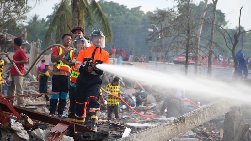 A firefighter sprays water after an explosion at a firework warehouse in Narathiwat province southern Thailand (Kriya Tehtani/AP)