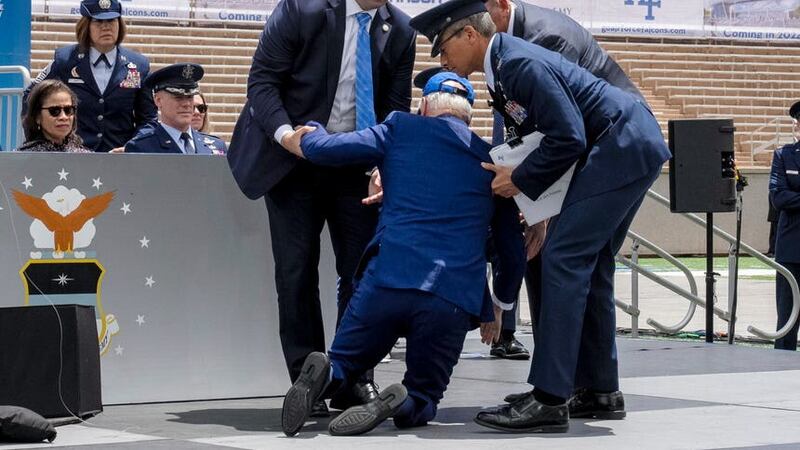 Joe Biden was helped up by an air force officer and two members of his secret service detail (Andrew Harnik/AP)