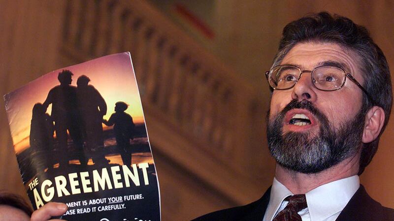 Sinn F&eacute;in leader Gerry Adams holds a copy of the Good Friday Agreement in 1998