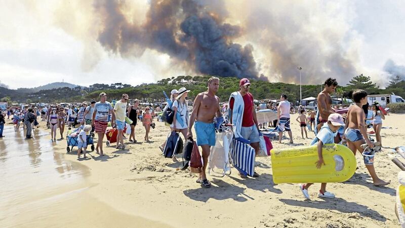 Evacuation of beach at Le Lavandou, French Riviera as plumes of smoke rise from burning wildfires on Wednesday PICTURE: Claude Paris/AP 