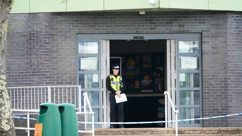 A police officer stands at the entrance to Amman Valley School, in Ammanford, Carmarthenshire