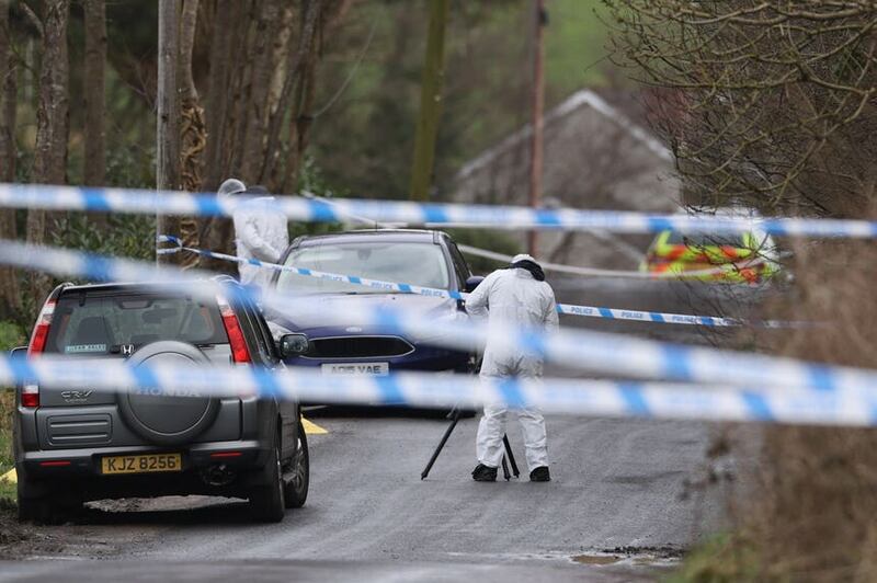 A forensic investigator from the PSNI takes photographs at the scene (Liam McBurney/PA)