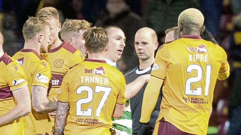 Motherwell players confront the referee after a controversial late penalty award 