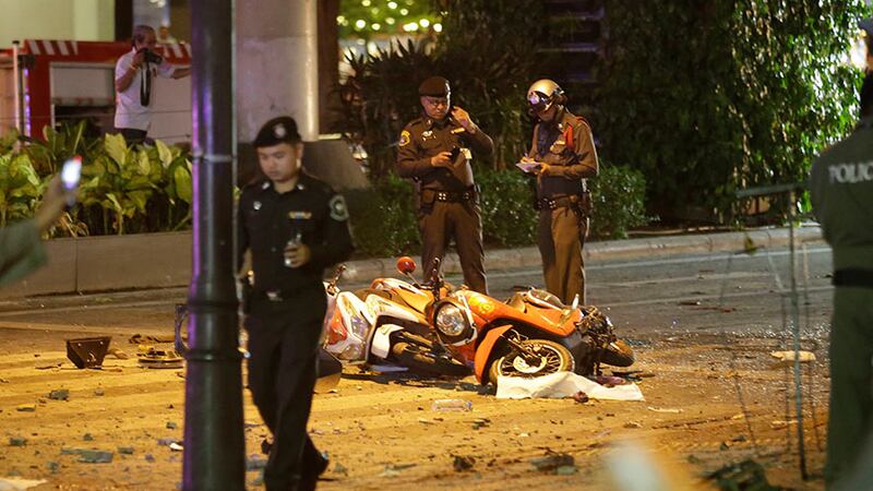Police examine the scene following today's explosion in Bangkok