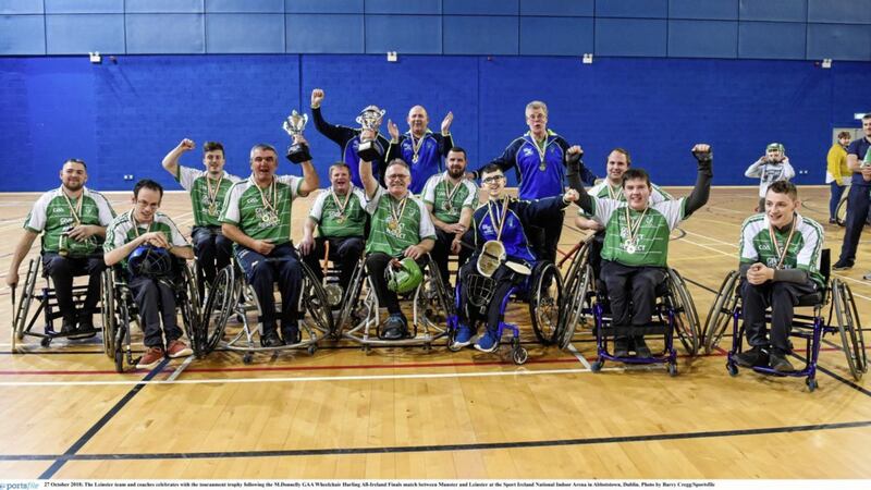 The Leinster team and coaches celebrates with the touranment trophy following the M.Donnelly GAA Wheelchair Hurling All-Ireland Finals match between Munster and Leinster at the Sport Ireland National Indoor Arena in Abbotstown, Dublin on October 27 2018. Picture by Barry Cregg/Sportsfile 