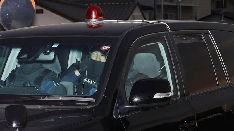 The suspect arrives at a police station (Kyodo News via AP)