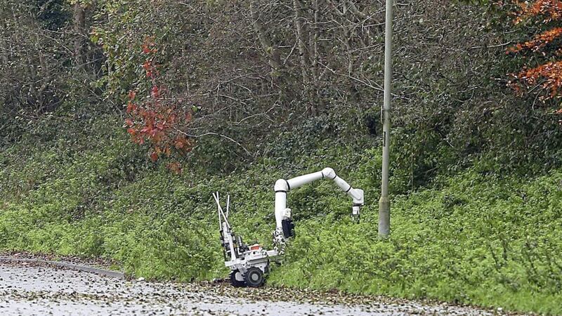 A bomb disposal robot removes an item from undergrowth as a security alert continues on the Pantridge Road in Poleglass. Picture by Mal McCann 