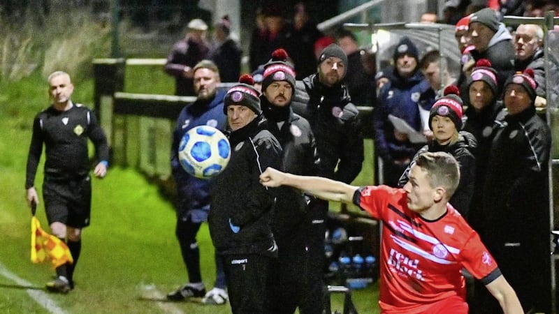 Ballyclare's Ian Fletcher under the watchful eye of the Comrades bench during their 3-0 Lough 41 Championship defeat at Dundela on Friday evening.