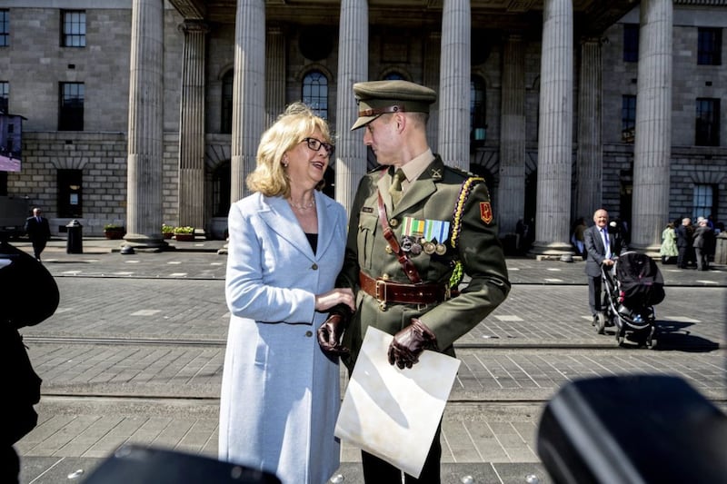 Former President Mary McAleese congratulates defence forces Captain Paul Conlon after he read the Proclamation during an Easter Rising commemoration at the GPO in Dublin. Picture by Liam McBurney, Press Association