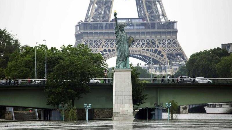 A replica of the Statue of Liberty stands tall over the flooded River Seine. Picture by Jerome Delay, Associated Press