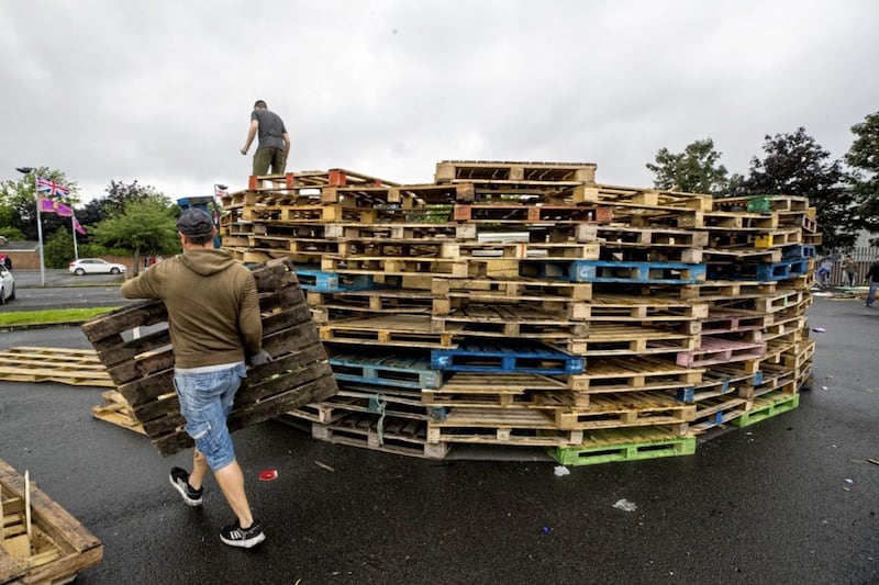 Men begin to build a new bonfire after removing material from a July 11th night bonfire at Avoniel Leisure Centre shortly after a Belfast City Council committee voted to send contractors in to remove material. Picture by Liam McBurney/PA Wire&nbsp;