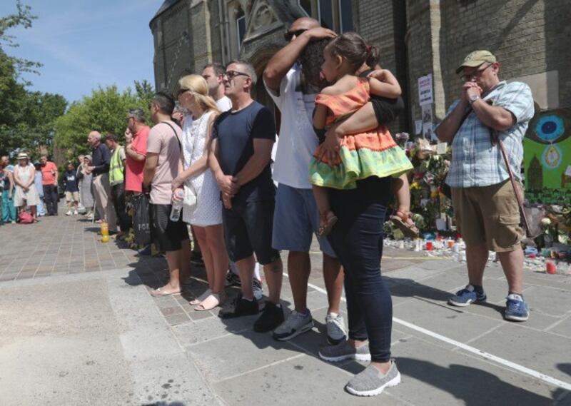 People observe a minute's silence near Grenfell Tower (Jonathan Brady/PA) Wire