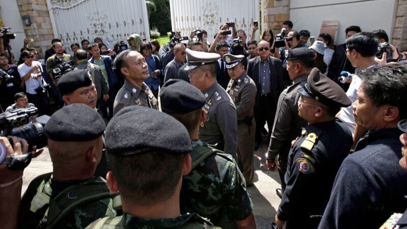 Thai policemen and soldiers gather in front of the house of former Prime Minister Yingluck Shinawatra with a search warrant in Bangkok, on Thursday PICTURE: Sakchai Lalit/AP 