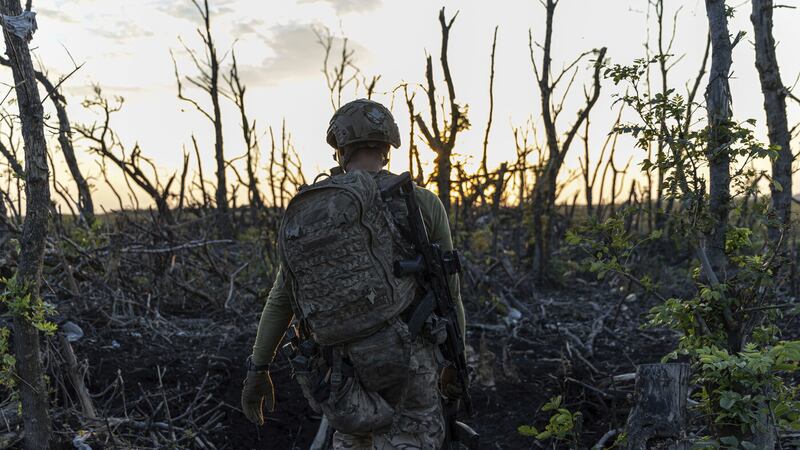 Assault unit commander from 3rd Assault Brigade who goes by the call sign 'Fedia' walks to his position through the tree line at the frontline a few kilometers from Andriivka, Donetsk region, Ukraine on Saturday, September 16, 2023. (AP Photo/Alex Babenko).